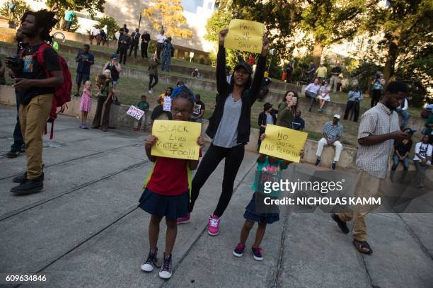 Children hold up signs during a demonstration against police brutality in Charlotte, North Carolina, on September 21 following the shooting of Keith...