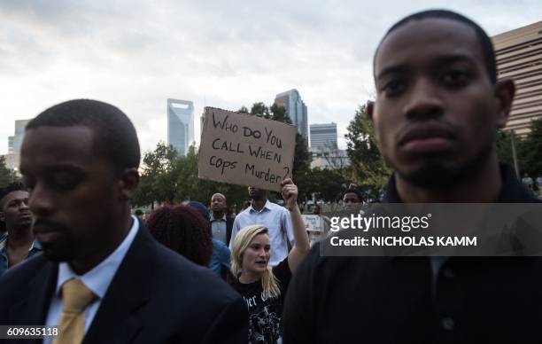 Protesters hold up signs during a demonstration against police brutality in Charlotte, North Carolina, on September 21 following the shooting of...