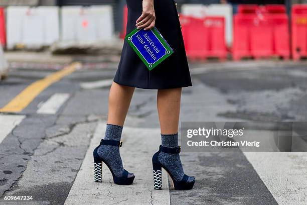 Is Fashion and lifestyle blogger Nour Arida wearing Poise Design platforms , Calzedonia glittery socks, 'Yazbuky' clutch seen outside during Milan...