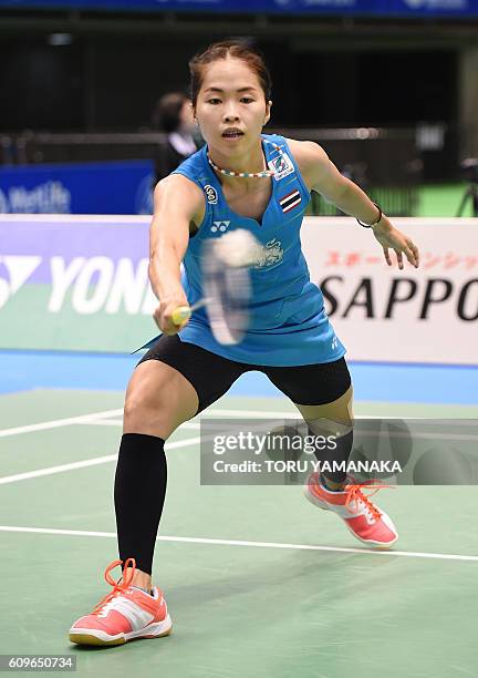 Ratchanok Intanon of Thailand returns a shot against Minatsu Mitani of Japan during their women's singles second round match at the Japan Open...