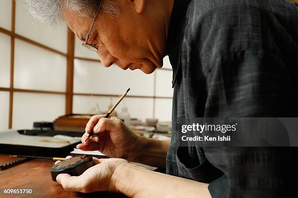 Lacquer artist and Japanese living national treasure Kazumi Murose paints on a lacquerware at the Mejiro Institute of Urushi Conservation on August...