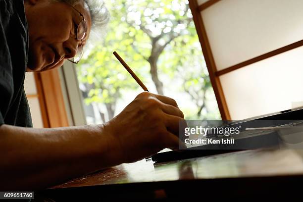 Lacquer artist and Japanese living national treasure Kazumi Murose paints on a lacquerware at the Mejiro Institute of Urushi Conservation on August...
