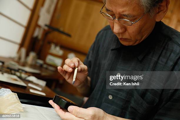 Lacquer artist and Japanese living national treasure Kazumi Murose paints on a lacquerware at the Mejiro Institute of Urushi Conservation on August...