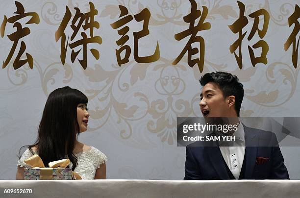 Taiwanese table tennis player Chiang Hung-chieh speaks with his Japanese wife Ai Fukuhara during a press conference in Taipei on September 22, 2016....