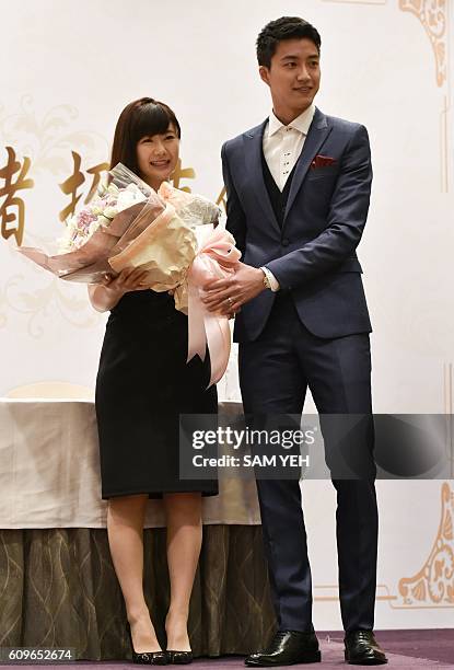 Taiwanese table tennis player Chiang Hung-chieh presents a bouquet of roses to his Japanese wife Ai Fukuhara during a press conference in Taipei on...