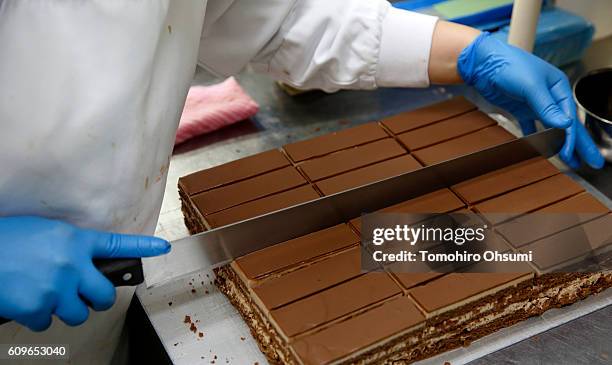 An employee cuts the Chocolatine cake at the Henri Charpentier factory on August 17, 2016 in Yokohama, Japan. Isetan Mitsukoshi Holdings Ltd....