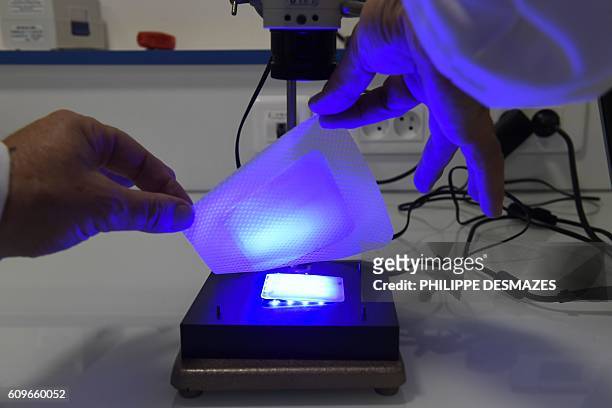 Picture taken on September 20, 2016 shows a man working on an innovative solution for wound healing by individualized light therapy at the URGO's...