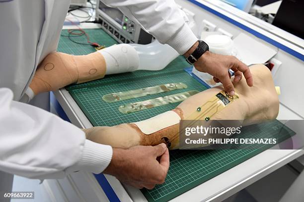 Picture taken on September 20, 2016 shows an electronic sensor and a wound dressing on a legform at the URGO's research and development center in...