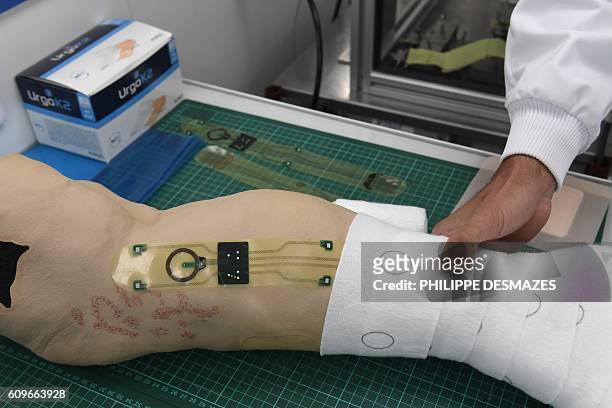 Picture taken on September 20, 2016 shows an electronic sensor and a wound dressing on a legform at the URGO's research and development center in...