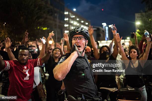 Police officer communicates with other officers September 21, 2016 in Charlotte, NC. Protests in Charlotte began on Tuesday in response to the fatal...