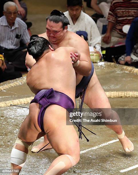 Ozeki Kisenosato pushes Tochiozan out of the ring to win during day two of the Grand Sumo Autumn Tournament at Ryogoku Kokugikan on September 12,...