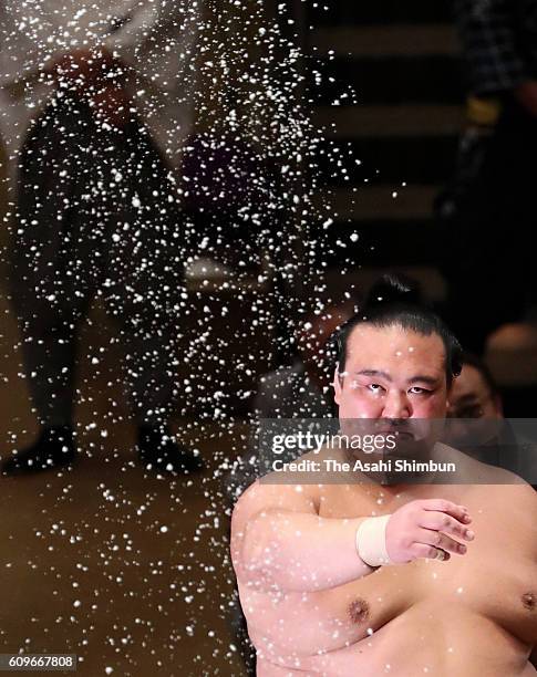 Ozeki Kisenosato splashes salt in preparation for his bout against Tochiozan during day two of the Grand Sumo Autumn Tournament at Ryogoku Kokugikan...