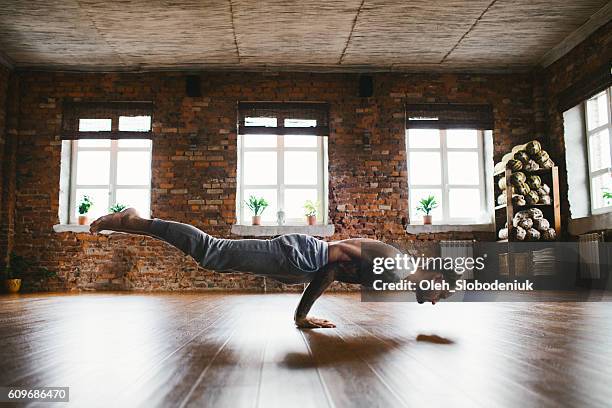 mann macht yoga im studio - frau macht yoga stock-fotos und bilder