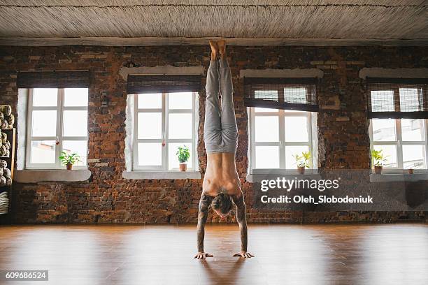 man doing yoga in studio - handstand stock pictures, royalty-free photos & images