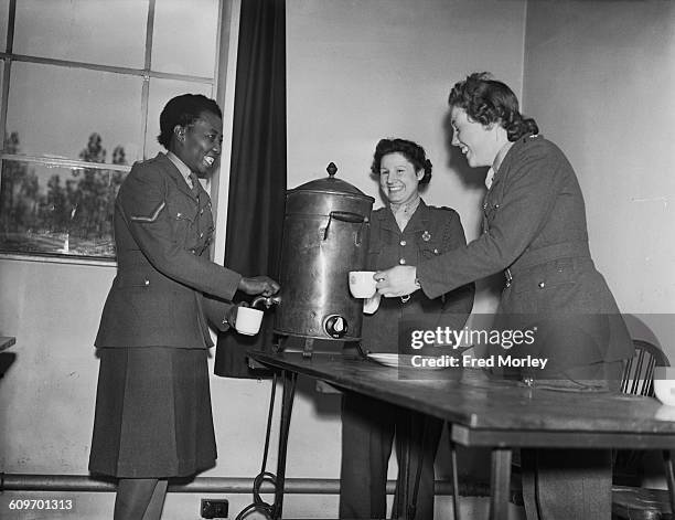 Lance Corporal Adina Williams of the British Auxiliary Territorial Service pours a cup of tea from an urn in the canteen at her barracks, UK, 26th...