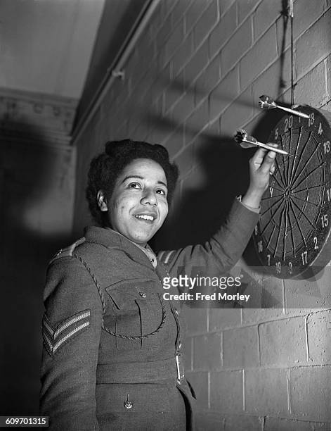Corporal Hinds of the British Auxiliary Territorial Service playing darts at an ATS training centre in the UK, 18th December 1942. Hinds, who is...