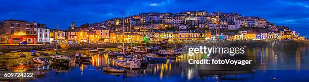 quaint fishing village harbour cottages illuminated dusk panorama brixham devon - fishing village stock pictures, royalty-free photos & images