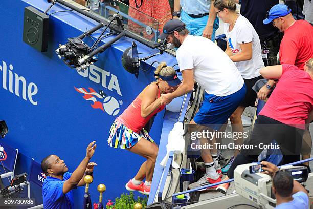 Open - Day 13 Angelique Kerber of Germany climbs into her team box to celebrate her win against Karolina Pliskova of the Czech Republic in the...