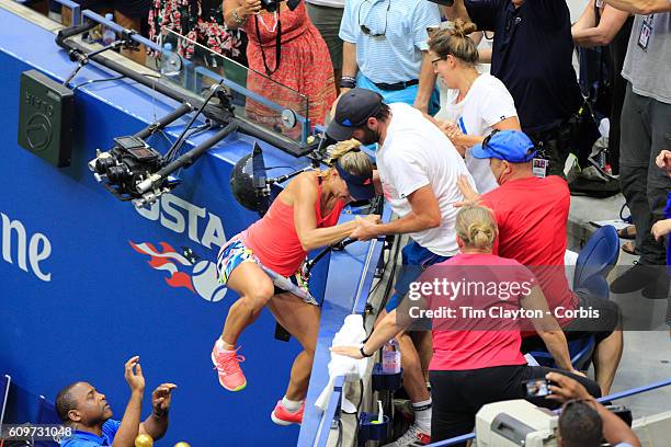 Open - Day 13 Angelique Kerber of Germany climbs into her team box to celebrate her win against Karolina Pliskova of the Czech Republic in the...