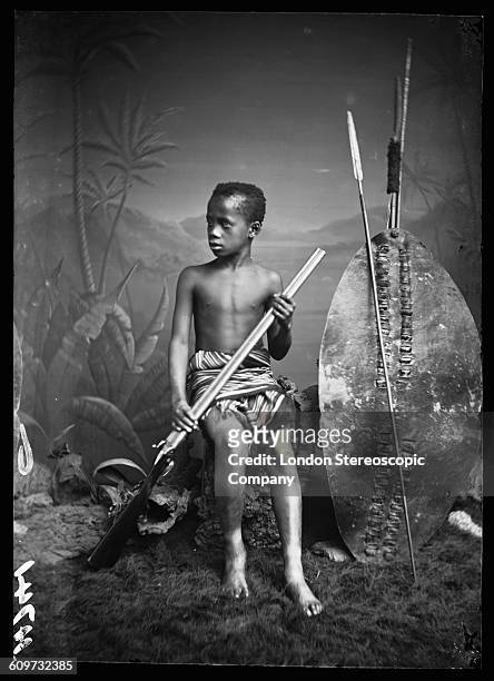 An unidentified boy, referred to as 'Zulu Boy' and possibly as 'Samba Klaas' in London Stereoscopic Company documentation, holding a spear and...