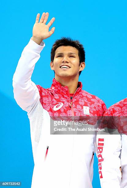 Bronze medalist Keiichi Kimura of Japan celebrates on the podium at the medal ceremony for the Men's 100m Breaststroke - SB11 on day 6 of the 2016...
