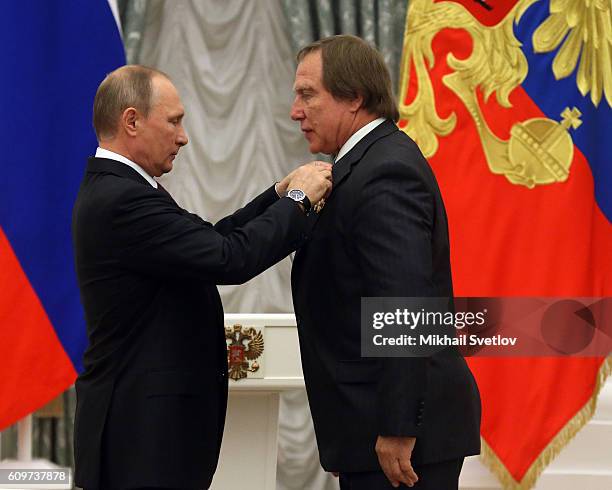 Russian President Vladimir Putin gives an order to businessman and cellist Sergei Roldugin during the state awarding ceremony at the Kremlin in...