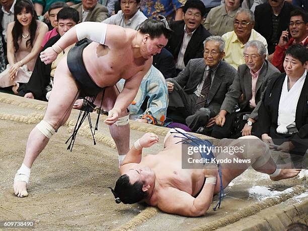 Yokozuna Harumafuji of Mongolia throws down ozeki Kotoshogiku on the 12th day of the Autumn Grand Sumo Tournament at Tokyo's Ryogoku Kokugikan on...