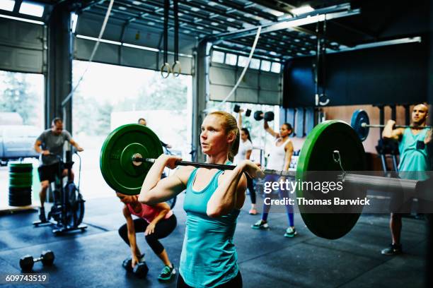 woman preparing to press barbell overhead - cross training stock pictures, royalty-free photos & images