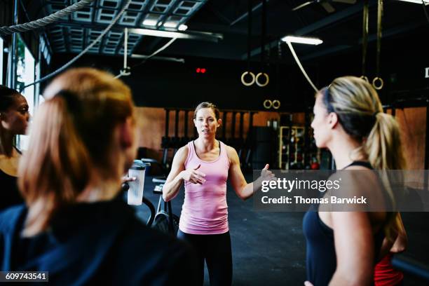 woman leading gym class with group of women - sport manager stock pictures, royalty-free photos & images