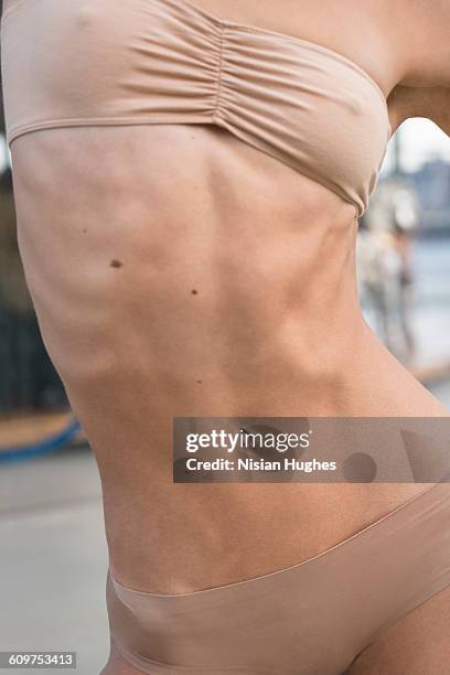 cropped image of fit woman stomach - couleur chair photos et images de collection