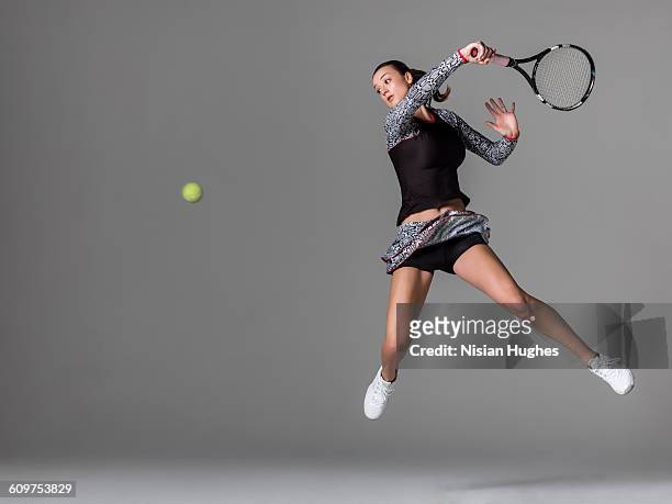 young woman playing tennis hitting forhand - tennis stock-fotos und bilder