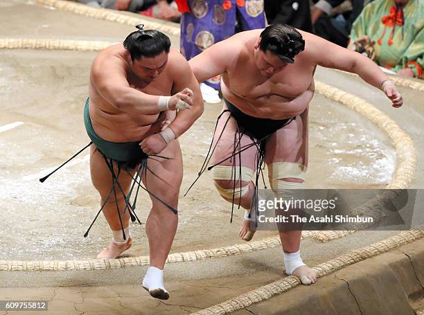 Okinoumi pushes Mongolian ozeki Terunofuji to win during day four of the Grand Sumo Autumn Tournament at Ryogoku Kokugikan on September 14, 2016 in...