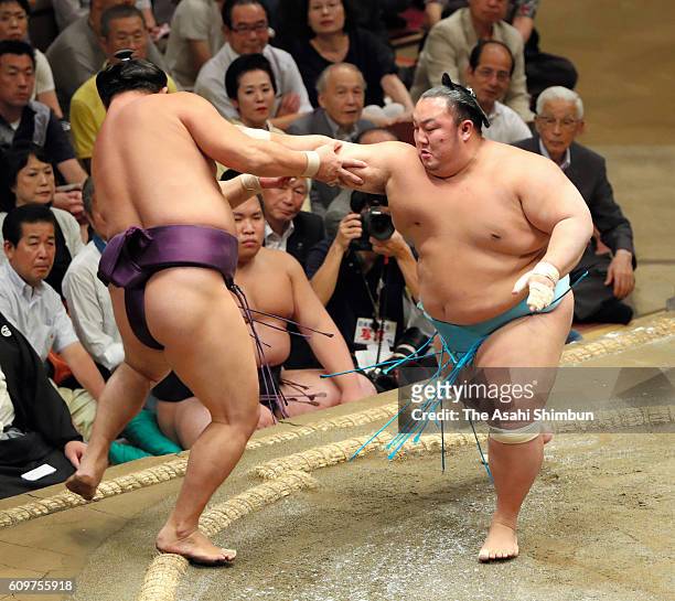 Kotoyuki pushes Chinese wrestler Sokokurai out of the ring to win during day four of the Grand Sumo Autumn Tournament at Ryogoku Kokugikan on...