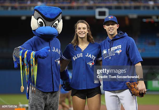 Canadian Olympian in Rio Penny Oleksiak poses with mascot Ace and Aaron Sanchez after throwing out the first pitch before the start of the Toronto...