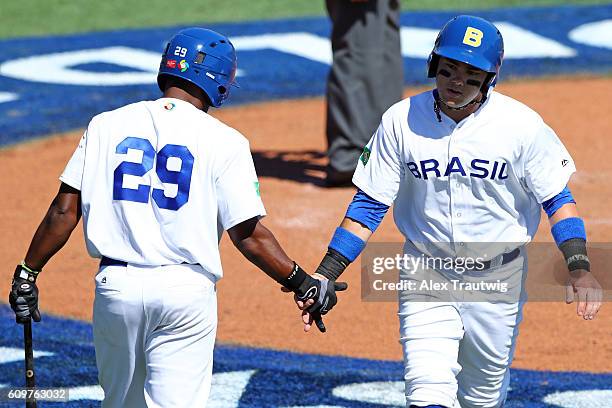 Dante Bichette Jr of Team Brazil is greeted by teammate Juan Carlos Muniz after scoring a run during Game 1 of the 2016 World Baseball Classic...