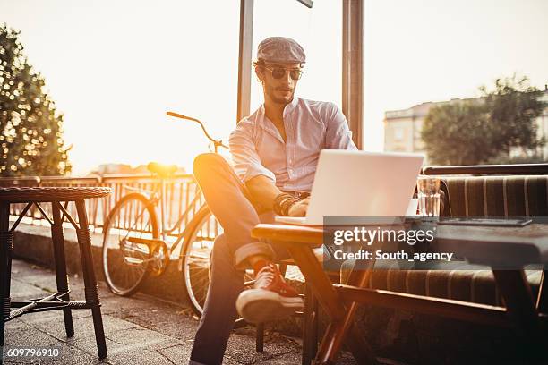 hipster im café auf laptop - sunny days stock-fotos und bilder