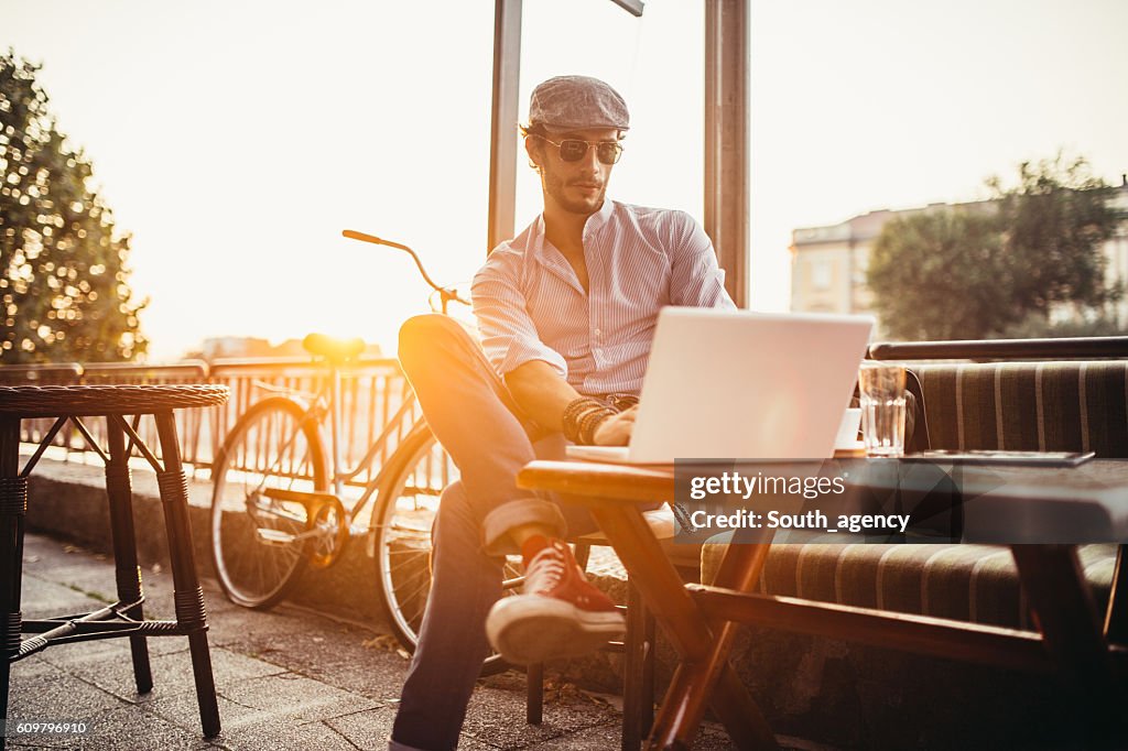 Hipster dans un café sur ordinateur portable