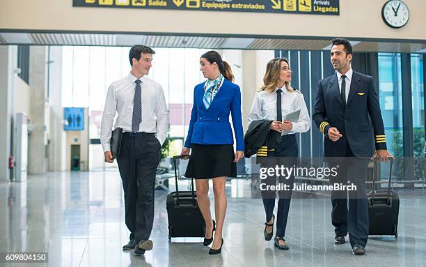 tripulación de vuelo caminando por el aeropuerto - azafata fotografías e imágenes de stock