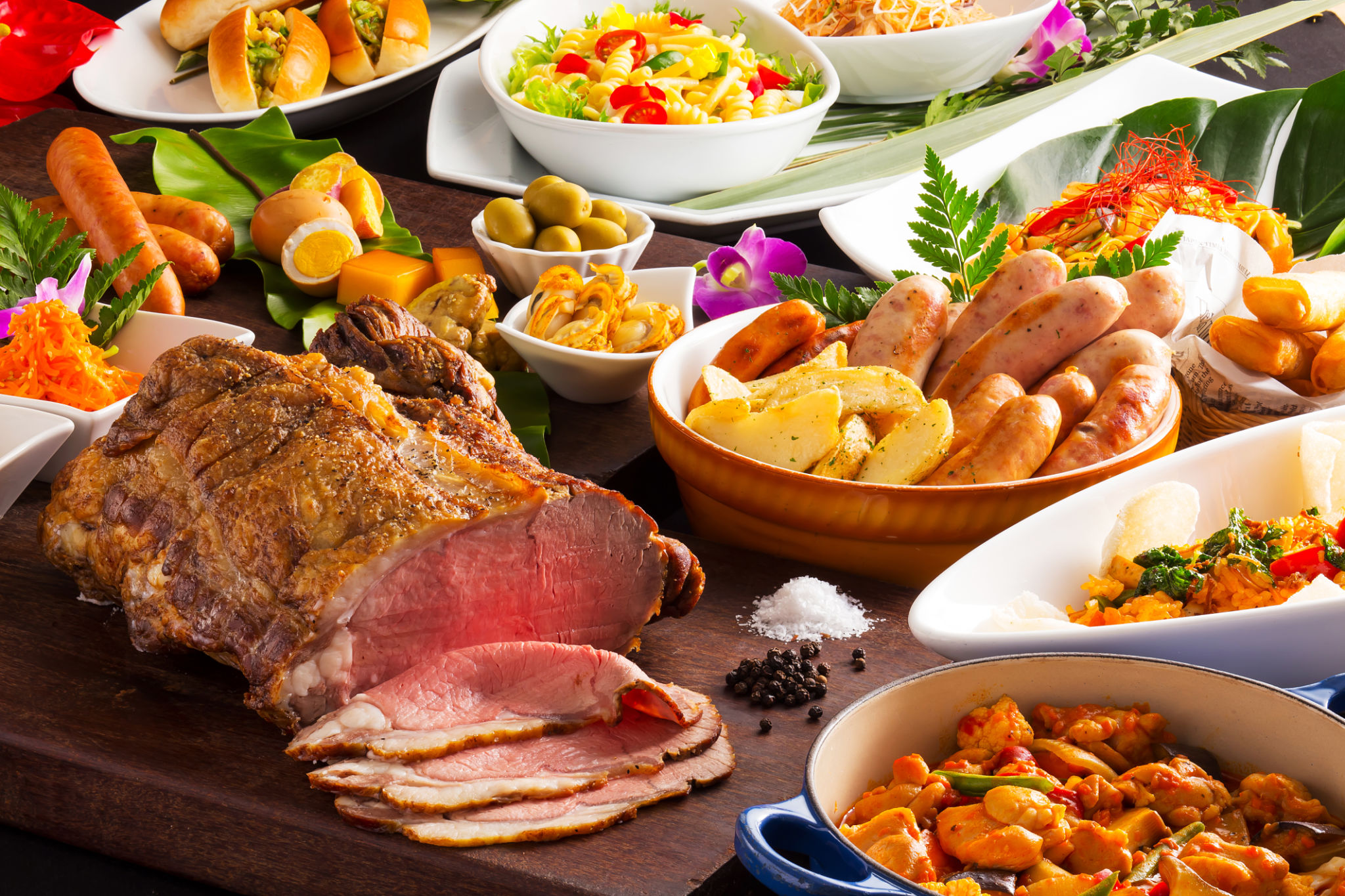 Table of food with grilled beef, sausages, pasta, fried tomatoes Table of food with grilled beef, sausages, pasta, fried tomatoes