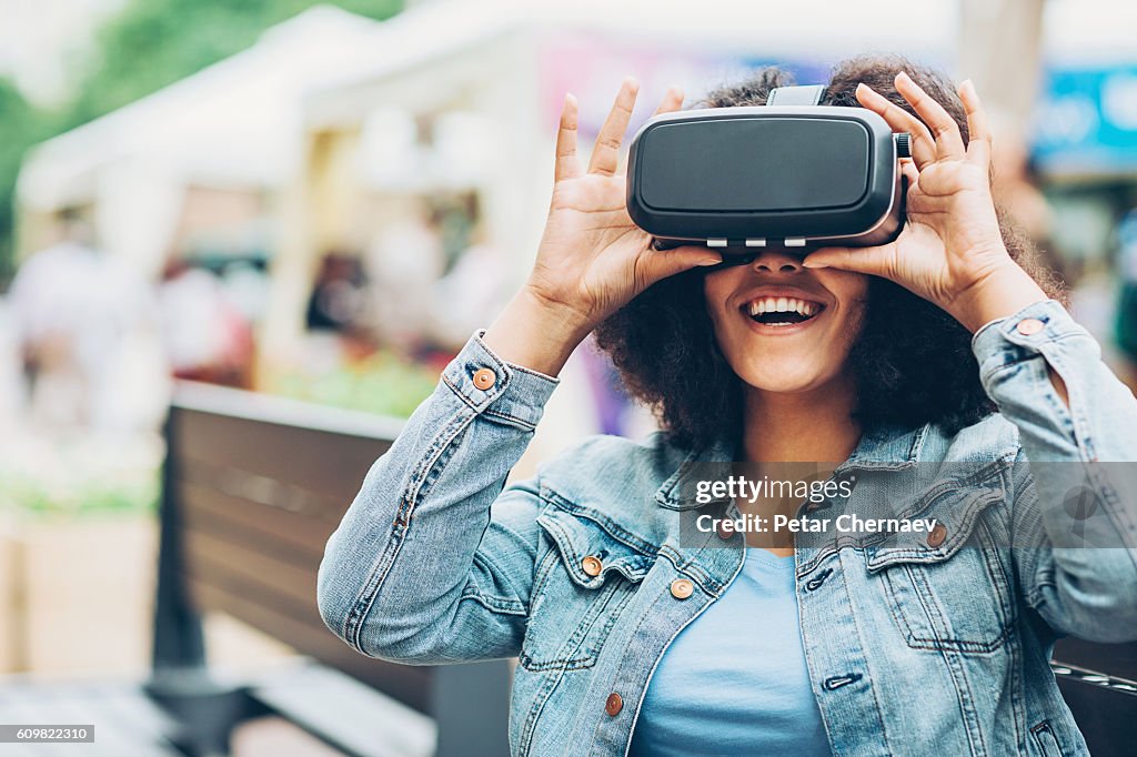 Smiling girl looking through a virtual reality headset