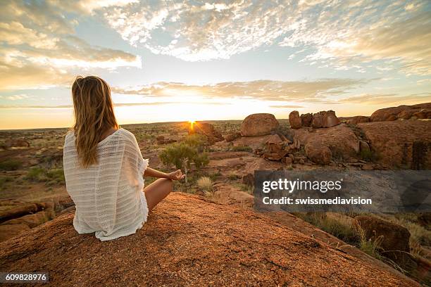 caucasian female exercising yoga at sunrise - female bush photos stockfoto's en -beelden