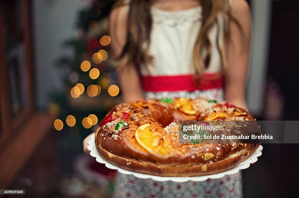 Cute little girl holding a Christmas sweet at home.