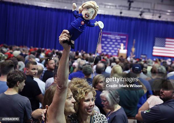 Woman holds up a doll in the likeness of Democratic presidential nominee Hillary Clinton while Republican presidential candidate Donald Trump speaks...