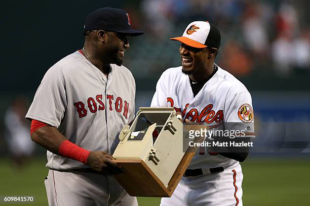 Adam Jones of the Baltimore Orioles presents David Ortiz of the Boston Red Sox with the dugout telephone Ortiz broke on July 27, 2013 during his...