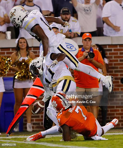 Lance Austin of the Georgia Tech Yellow Jackets fumbles an interception into the end zone as he is hit by teammate Corey Griffin and Mike Williams of...