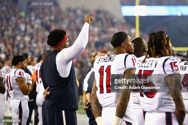 Duane Brown of the Houston Texans raises his fist during the national anthem before the game against the New England Patriots at Gillette Stadium on...