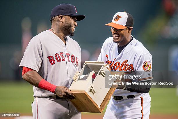 Adam Jones of the Baltimore Orioles presents a replica dugout phone to David Ortiz of the Boston Red Sox during an honorary pre game ceremony for...