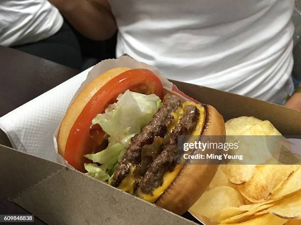 Southern Californian burger chain ‘In-n-Out Burger’ open a pop up restaurant in Swiss Cottage, London. Burger fans were queuing from 9 am for a...