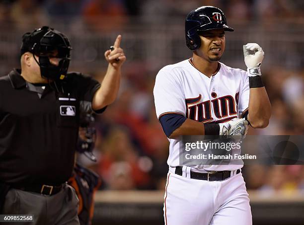 Eduardo Escobar of the Minnesota Twins reacts to being hit by a pitch by Justin Verlander of the Detroit Tigers as home plate umpire Eric Cooper...