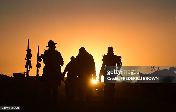 Festival goers arriving at sunset attend the first day of Wasteland Weekend in the high desert community of California City in the Mojave Desert,...